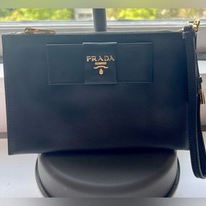 Authentic Prada wristlet in black with gold hardware.
